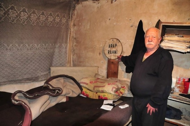 Yaşlı Adam, Mezar Tahtası Başucunda Uyuyor