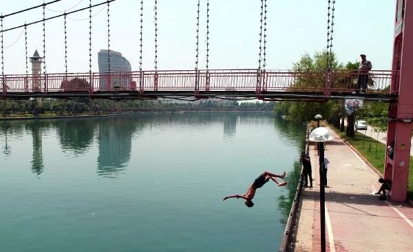 Sıcaklığın 47 dereceye ulaştığı Adana'da gençler serinlemek için Seyhan Nehri'ne atladı
