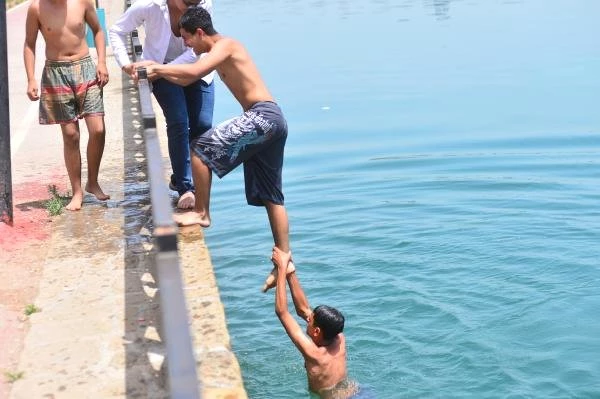 Sıcaklığın 47 dereceye ulaştığı Adana'da gençler serinlemek için Seyhan Nehri'ne atladı