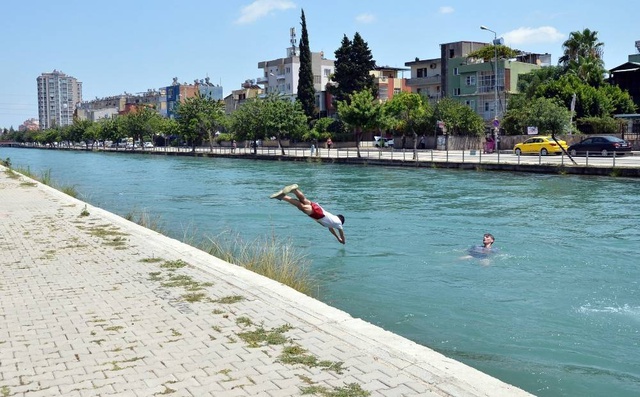 Termometrelerin 41 dereceyi gösterdiği Adana'da, serinlemek isteyen gençler tehlikeye aldırış etmedi