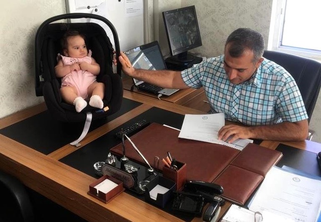 Okul müdürü çocuğa bakıyor, öğretmen de öğrencilere ders veriyor