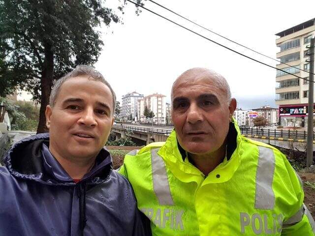 Trafik polisi, ayakkabılarını çıkararak aşırı yağış nedeniyle tıkanan mazgalları temizledi