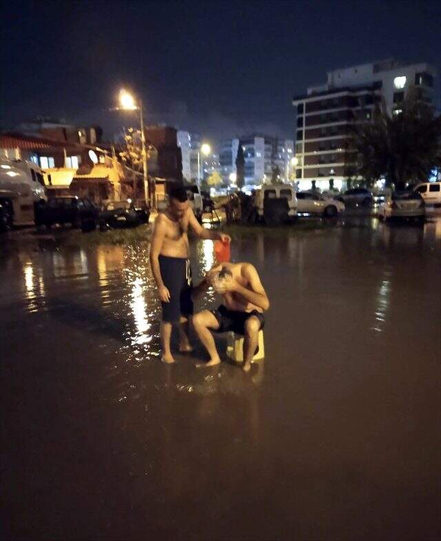 İzmir'de su kesintisine dikkati çekmek için yağmur suyuyla sokakta yıkandılar İzmir'de su kesintisine dikkati çekmek için yağmur suyuyla sokakta yıkandılar