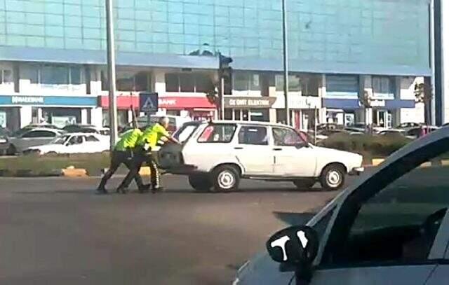 Yol ortasında bozulan aracı, trafik polisleri itti