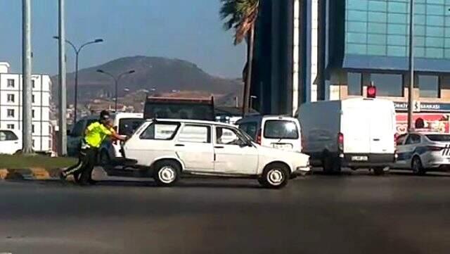 Yol ortasında bozulan aracı, trafik polisleri itti