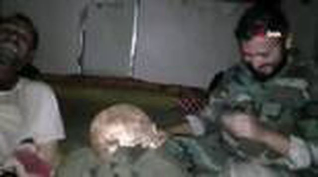 Esed rejimi askerleri mezardan kafatası çıkartıp video çekti