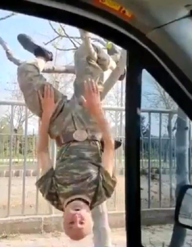 Sokağa çıkma yasağını dikkate almayan yaşlı adam, baş aşağı asıldığı ağaçta komando marşı söyledi