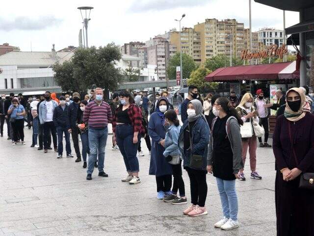 Vatandaşlar şiddetli yağmura rağmen AVM önünde kuyruğa girdi