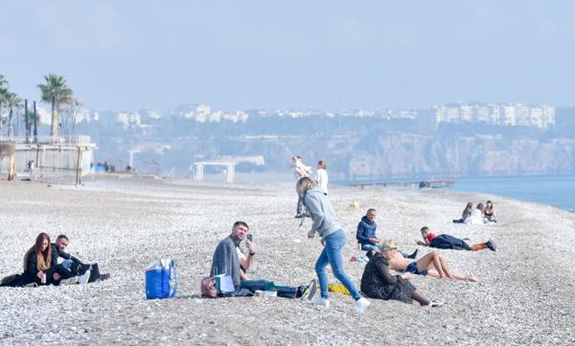 Kısıtlamada turistlerin sahilde güneş keyfi Kısıtlamada turistlerin sahilde güneş keyfi