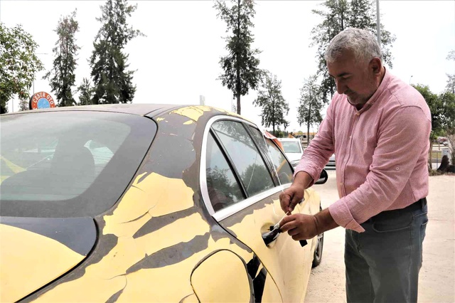 Aldığı lüks aracı işyerinin önüne koyup, üzerine 'Markanın ayıplı malıdır, 5 yıldır yatmakta' yazdı