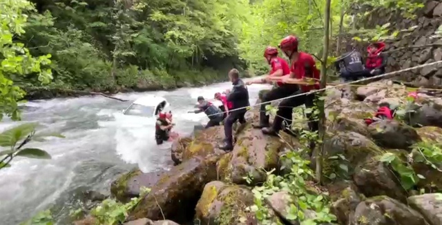 Rize'de dereye uçan aracın üzerine çıkarak yardım beklediler