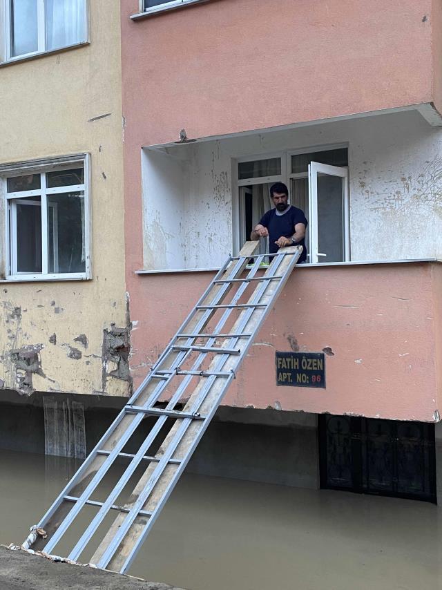 Selin yıktığı ilçeden bir manzara! Girişi suyla dolan binaya girmek için karyoladan köprü yaptılar