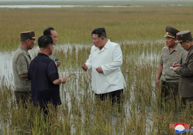 Kuzey Kore lider iKim Jung Un sel bölgesini ziyaret ettiği sırada yanındaki yetkililer ile beraber göbeğine kadar suya girdi