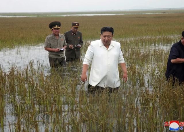 Kuzey Kore lider iKim Jung Un sel bölgesini ziyaret ettiği sırada yanındaki yetkililer ile beraber göbeğine kadar suya girdi