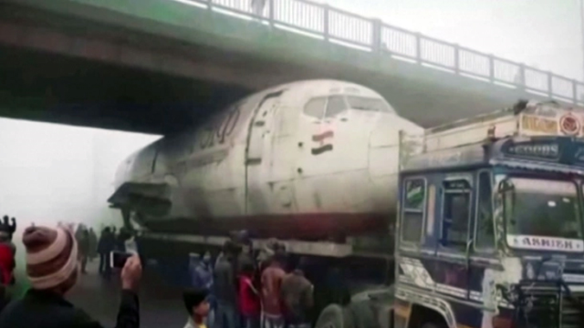 Hindistan'da hurdaya çıkan yolcu uçağının gövdesini taşıyan kamyon köprünün altına sıkıştı