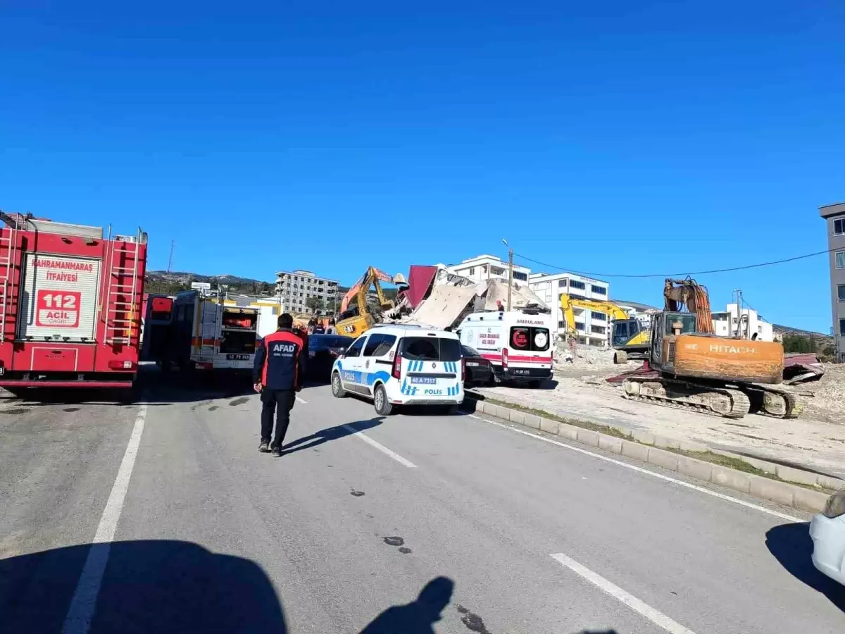 Depremde ağır hasar alan bina yıkım sırasında iş makinesinin üzerine