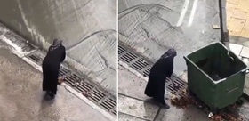 Belediye ekiplerini beklemeyen yaşlı kadın mazgalları bastonuyla temizledi