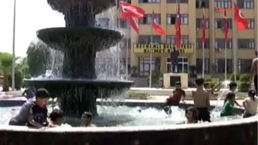 Reyhanlı'da Çocuklar Süs Havuzunda Serinliyor