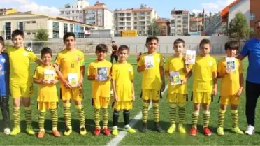 Küçük futbolcular yolculuk sırasında kitap okuyor