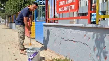 Okul müdürü elinde fırçayla okulu boyuyor