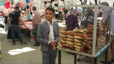 Takım elbisesiyle tezgah başına geçip, okul harçlığı için simit satıyor