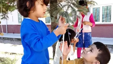 Minik öğrenciler kuşlar için ağaçlara yem astı