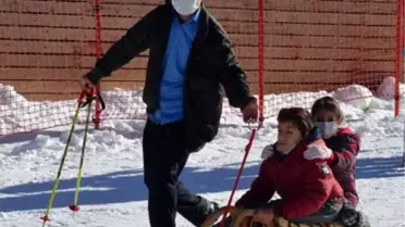 Sağlıkçılar için düzenlenen kayak kursunda engelli oğluna kızak keyfi yaşattı