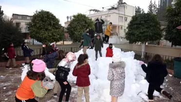 Kamyonla okul bahçesine taşınan kar öğrencilerin neşe kaynağı oldu