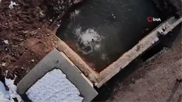 Etrafı karla kaplı doğal jakuzinin keyfini çıkarıyorlar