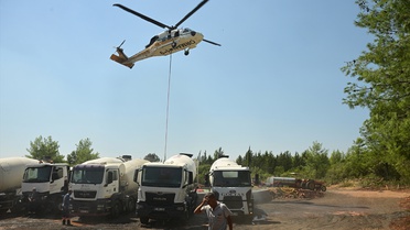 Antalya Aksu'da köylüler traktörlerle yangın havuzlarını doldurup helikopterlere su