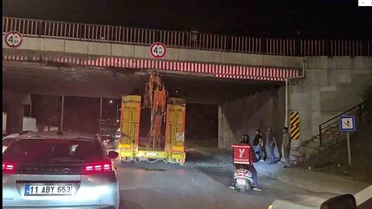 Eskişehir'de iş makinesi yüklü tır üst geçide takıldı, lastikleri indirilip kurtarıldı
