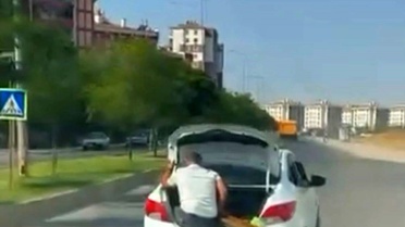 Diyarbakır'da bagaj kapısında oturan çocuk ve malzeme taşıyan kişi görüntülendi