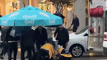 Bursa Osmangazi'de otomobil yayaya çarptı, çevredekiler yağmurda şemsiye tuttu