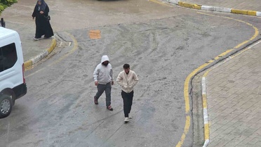 Van'da yağmura hazırlıksız yakalanan bazı vatandaşlar saçaklara sığındı