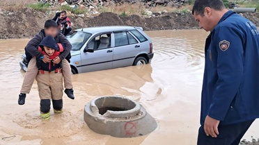 Hatay'da yoğun yağışta mahsur kalan araçtaki çocuk itfaiyecinin sırtında kurtarıldı