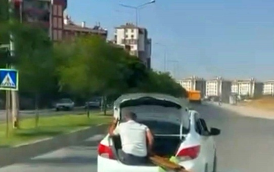 Diyarbakır'da bagaj kapısında oturan çocuk ve malzeme taşıyan kişi görüntülendi