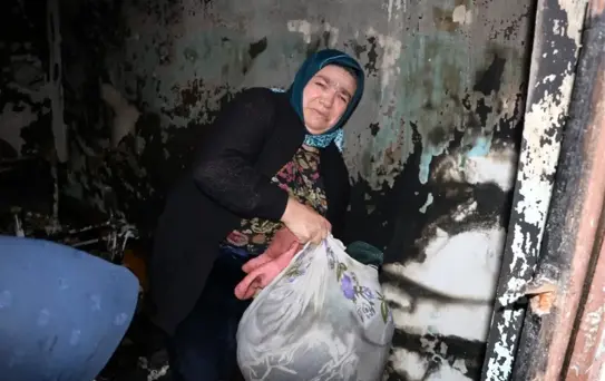 Evi yanan kadın eşyalarını gözyaşları içinde topladı