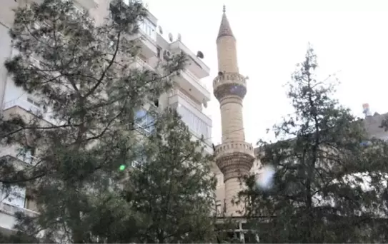 Binaların arasındaki ağır hasarlı cami minaresi, endişe veriyor! Aniden yıkılabilir