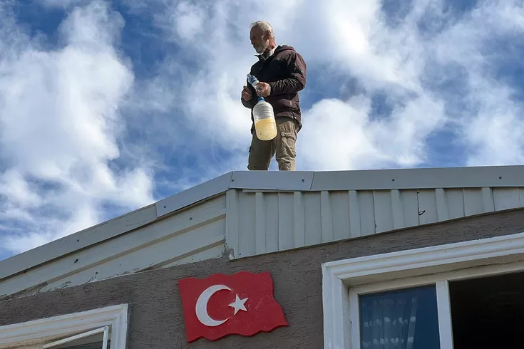 Kaçak evinin yıkımına engel olmak için benzin bidonuyla çatıya çıktı