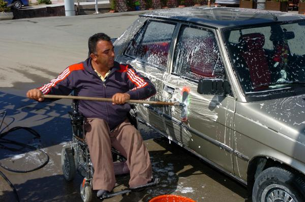 Tekerlekli Sandalyesinin Üzerinde Araçları Yıkıyor