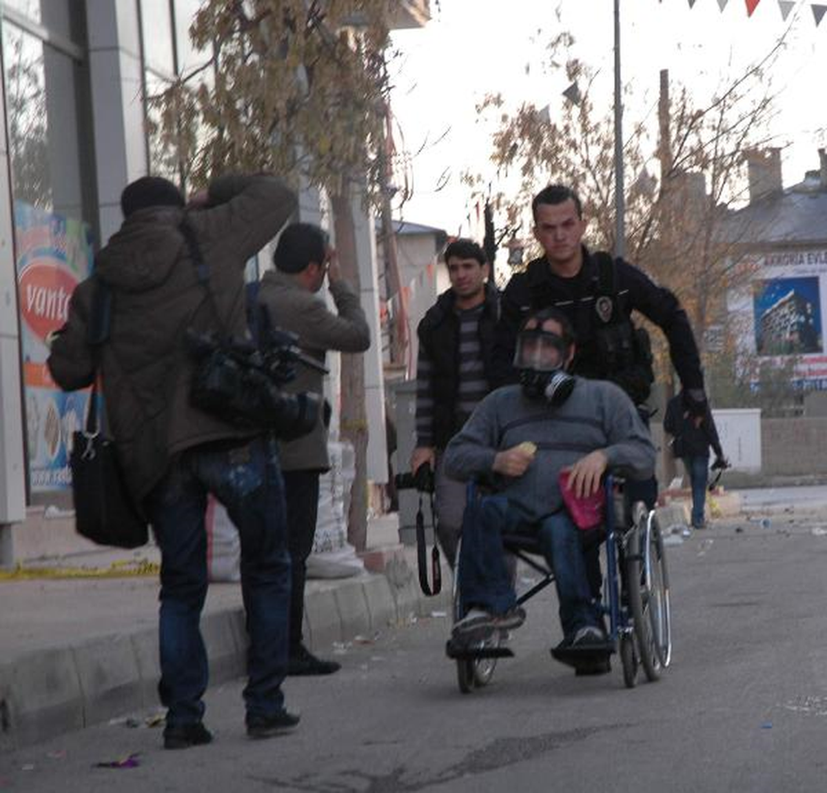 Gaz Maskesini Çıkartarak Tekerlekli Sandalyedeki Engelliye Taktı