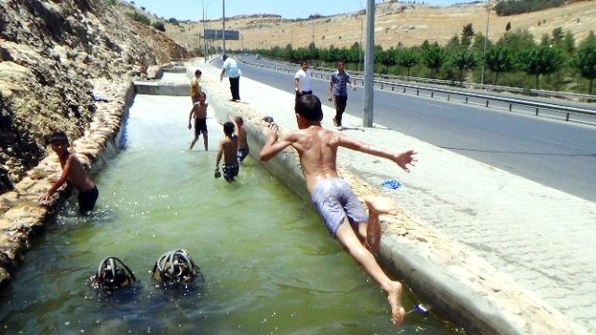 Şanlıurfa\'da Çocuklar Elektrikli Süs Havuzunda Serinliyor