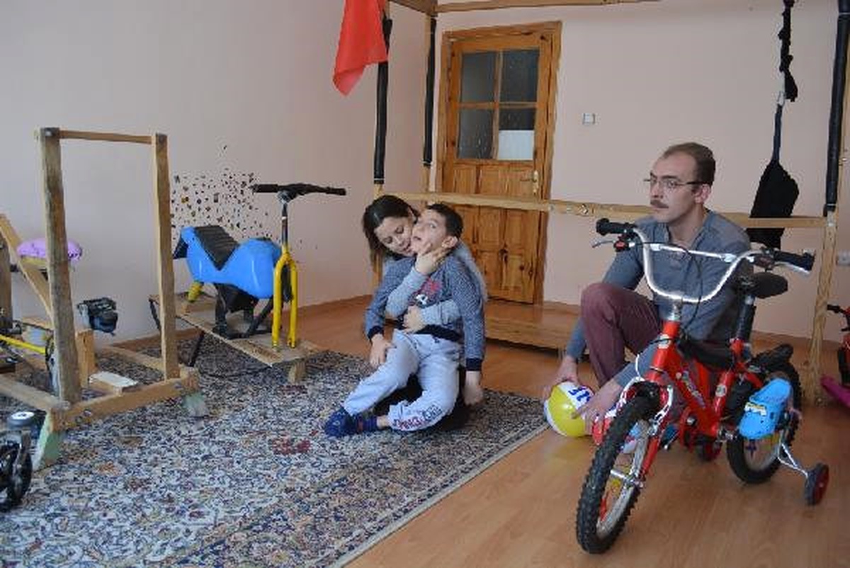 Tahtadan Yaptığı Fizik Tedavi Aletleri ile Çocuğunu Yürütmeye Çalışıyor