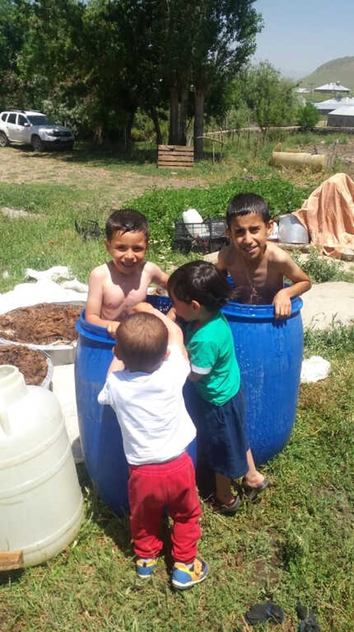 Ağrı\'da Sıcaktan Bunalan Çocuklar Su Dolu Varillerde Serinliyor