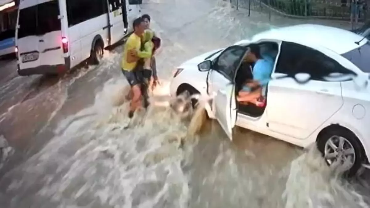 Akıntıya kapılıp, aracın altına sürüklenen çocuğu son anda kurtardı