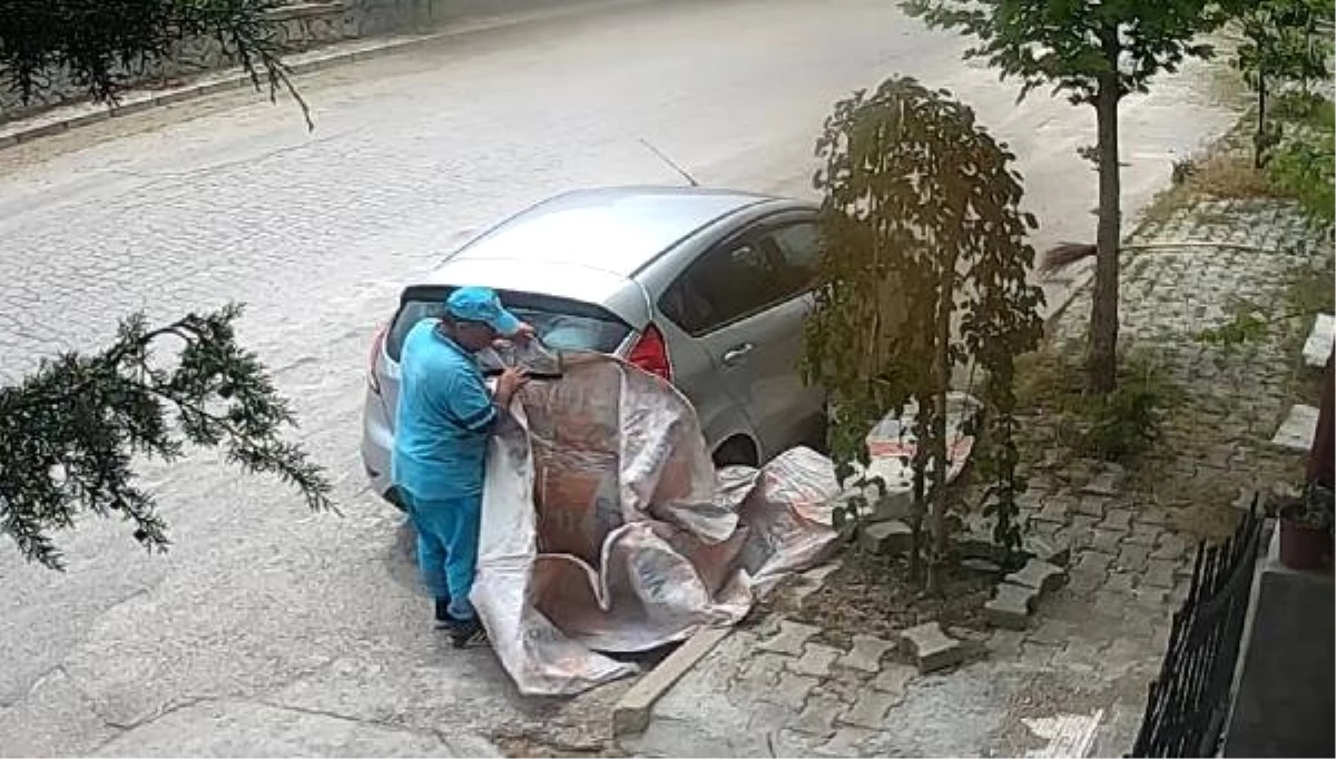 Belediyenin temizlik personeli kestiği otlar araca zarar vermesin diye aracın üzerini örttü