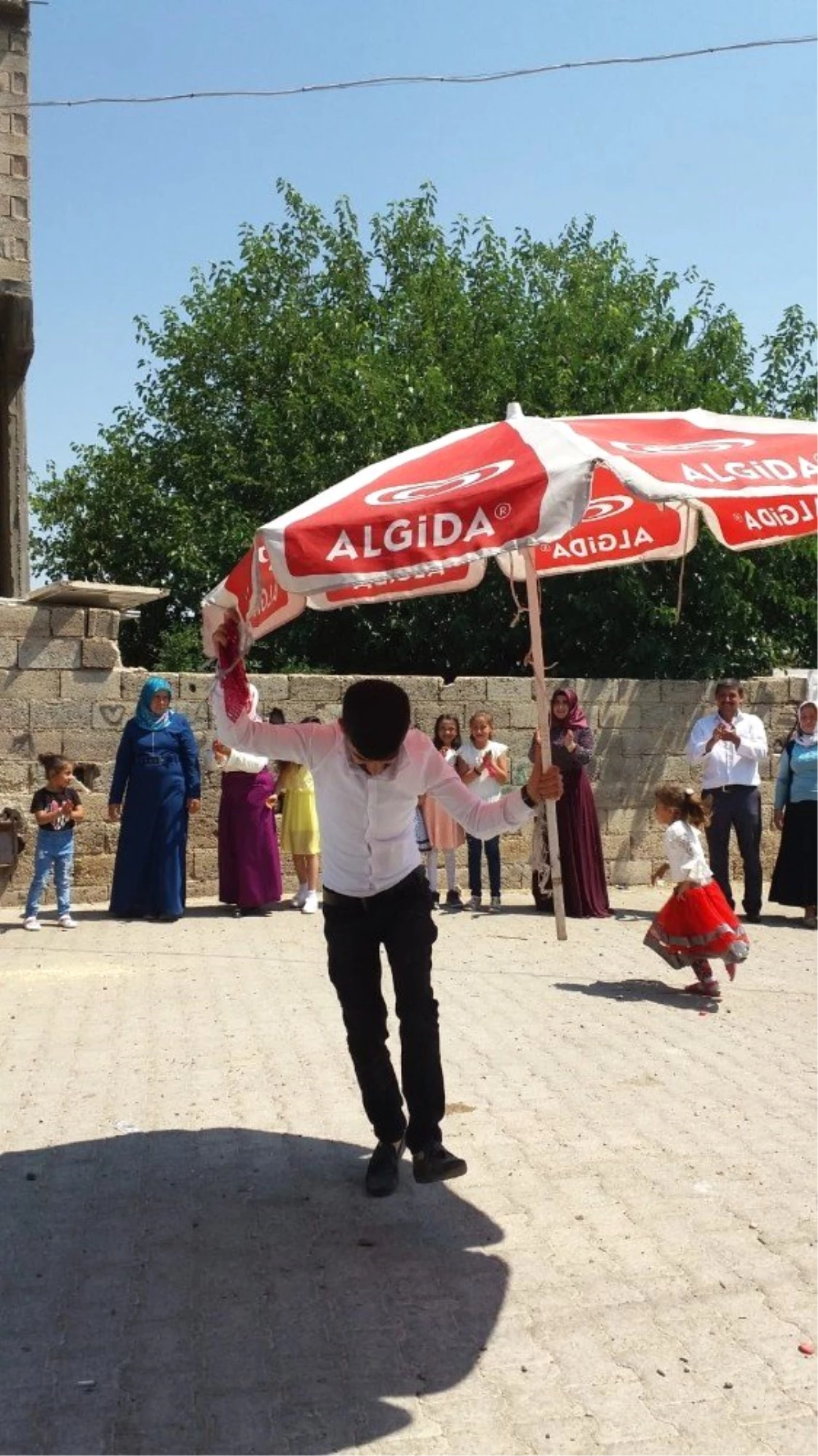 Kavurucu sıcak altında dev şemsiye ile halay