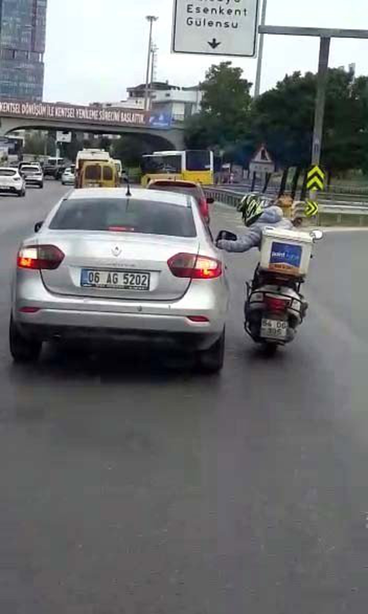 (Özel) Arızalanan motosikletiyle otomobilin camına tutunup seyahat eden motosikletli kamerada