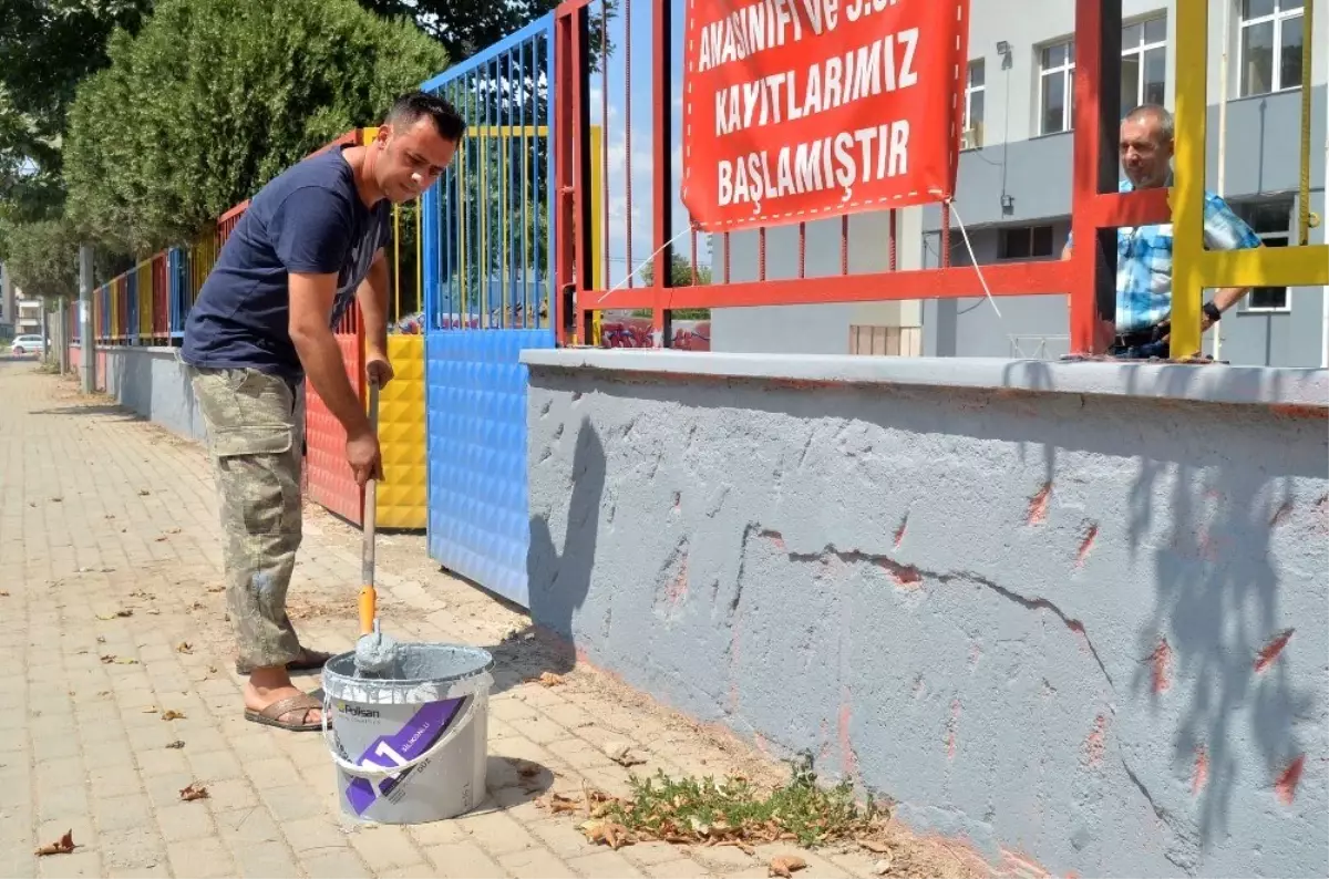 Okul müdürü elinde fırçayla okulu boyuyor