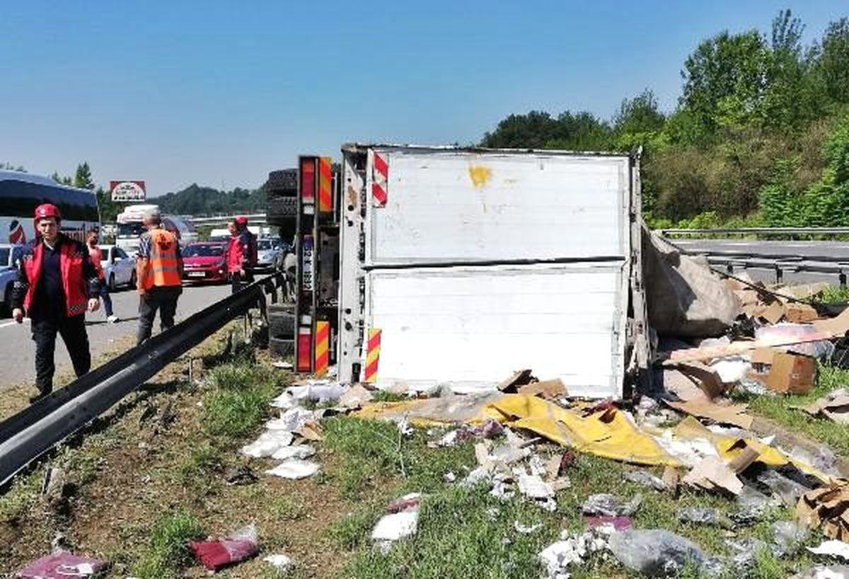 TEM\'de devrilen kamyondaki kıyafetler refüje saçıldı